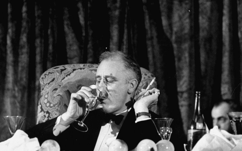 Image of FDR smoking and drinking what appears to be a martini.